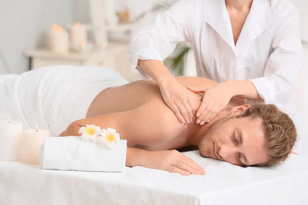 Ung man som får massage i spa salong — Stockfoto