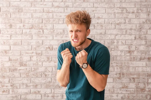 Portrait of angry man on brick background — Stock Photo, Image