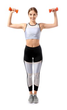 Beyaz arka planda dambıllar ile spor yapan genç bir bayan.