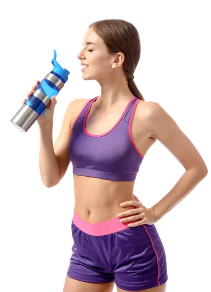 Sporty young woman drinking water against white background — Stock Photo, Image
