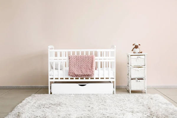 Stylish baby bed near light wall in interior of children's room — Stock Photo, Image