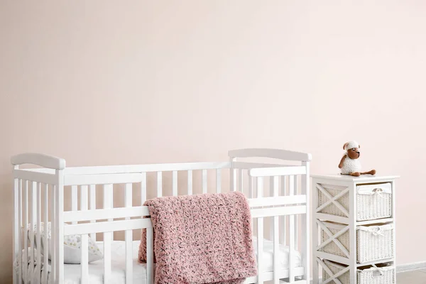 Κομψό κρεβάτι μωρού κοντά στο φως τοίχο στο εσωτερικό του παιδικού δωματίου — Φωτογραφία Αρχείου