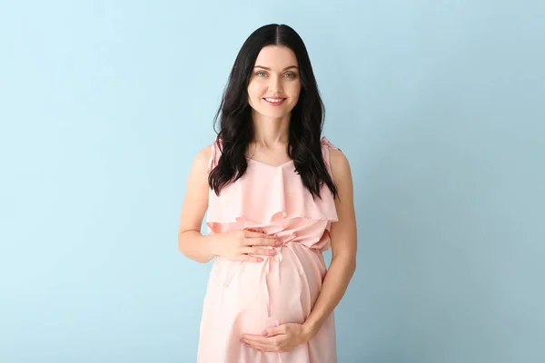 Renkli arka planda güzel hamile bir kadın. — Stok fotoğraf