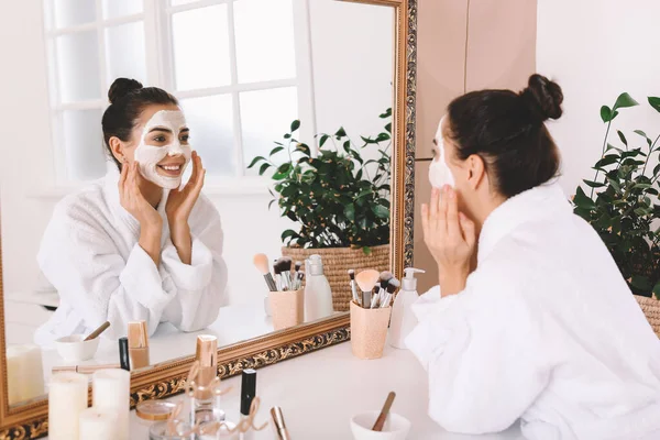 Hermosa joven aplicación de máscara facial en casa — Foto de Stock