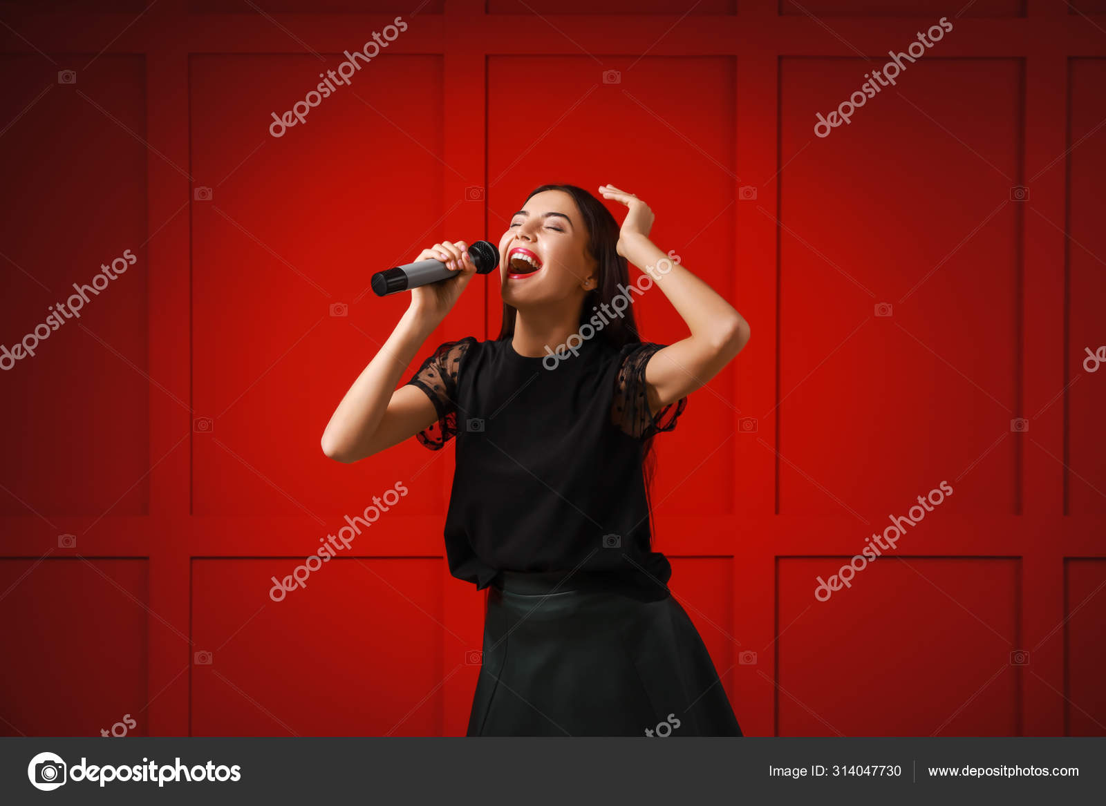 Beautiful young female singer with microphone on color background Stock