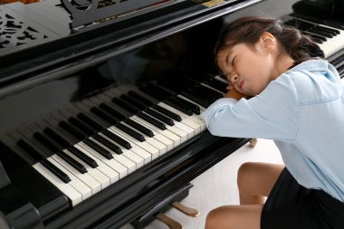 Evde piyano çalmayı reddeden küçük bir kız.