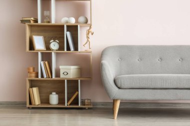 Modern raf ünitesi ve kanepe ışık duvarının yanında.