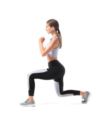 Beyaz arka planda spor yapan genç bir kadın.