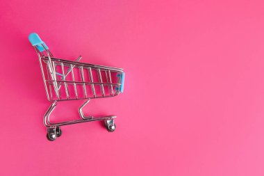 Renkli arka planda boş küçük alışveriş arabası