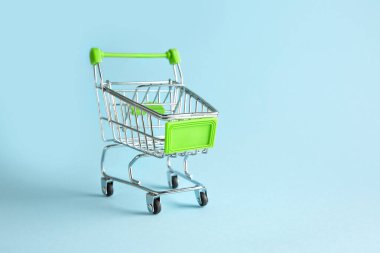 Renkli arka planda boş küçük alışveriş arabası