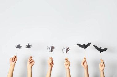 Işık arka planında Cadılar Bayramı dekoru olan birçok el