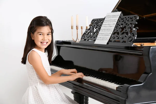 家でグランドピアノを弾く小さな女の子 — ストック写真
