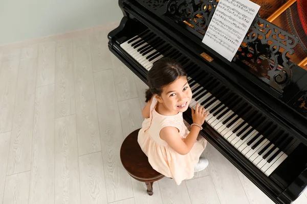 Little girl playing grand piano at home, top view — Stock Photo, Image