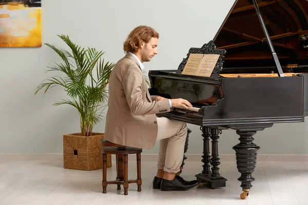Man playing grand piano at home — Stock Photo, Image