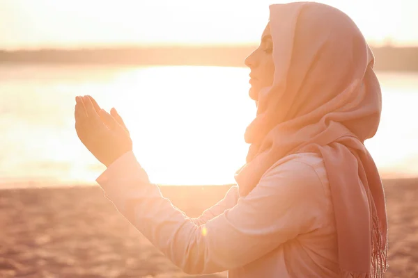 Schöne muslimische Frau betet im Freien bei Sonnenuntergang — Stockfoto