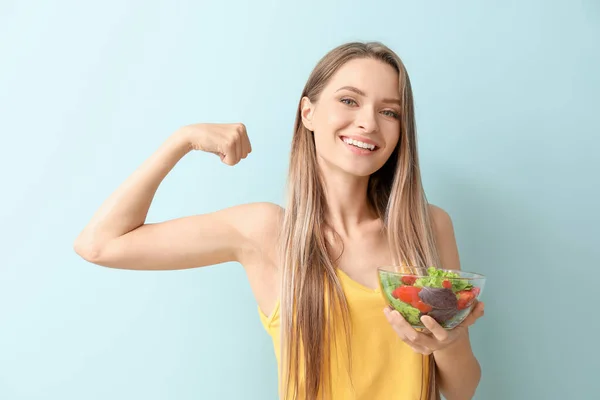 Glückliche Frau mit gesundem Gemüsesalat auf hellem Hintergrund. Ernährungskonzept — Stockfoto