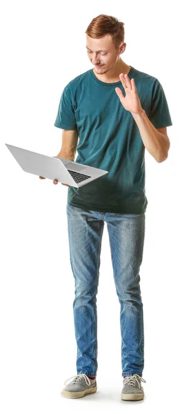 Hombre joven en elegante camiseta y con portátil sobre fondo blanco — Foto de Stock