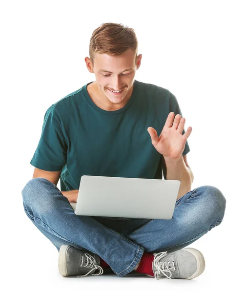 Hombre joven en elegante camiseta y con portátil sobre fondo blanco — Foto de Stock