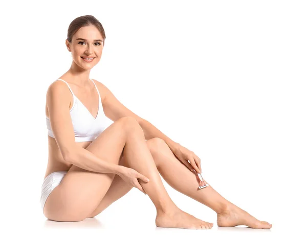 Piękna młoda kobieta golenia nóg na białym tle — Zdjęcie stockowe