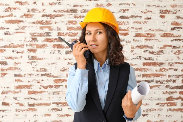 Portrait of female architect with portable radio transmitter against brick wall — Stock Photo, Image