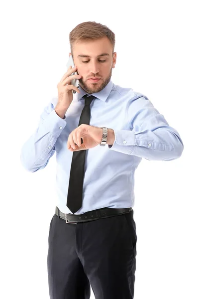 Πορτρέτο του όμορφος επιχειρηματίας κοιτάζοντας ρολόι, ενώ μιλάμε στο τηλέφωνο σε λευκό φόντο — Φωτογραφία Αρχείου