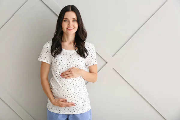 Vacker ung gravid kvinna på ljus bakgrund — Stockfoto