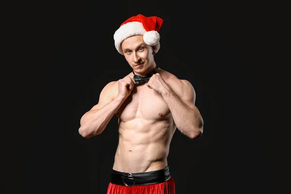 Young athletic Santa Claus on dark background — ストック写真