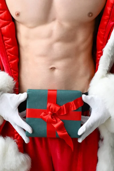 Young athletic Santa Claus with gift, closeup — Stock Photo, Image