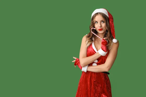 Mooie vrouw verkleed als Kerstman op kleur achtergrond — Stockfoto