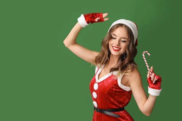 Mooie vrouw verkleed als Kerstman op kleur achtergrond — Stockfoto