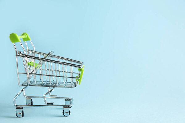 Пустой небольшой корзину для покупок на цветном фоне
