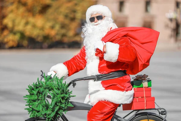 Papai Noel com presentes de Natal e bicicleta ao ar livre — Fotografia de Stock