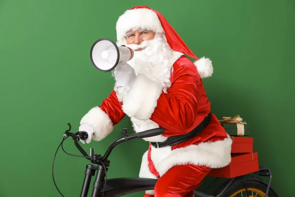 Santa Claus з мегафоном і велосипедом на кольоровому фоні — стокове фото