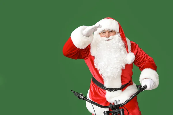 Santa Claus z rowerem patrząc daleko na tle koloru — Zdjęcie stockowe