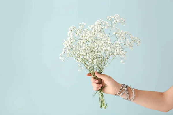 Female hand with bouquet of beautiful flowers on color background — Stock Photo, Image