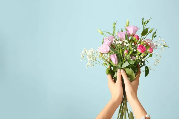 Manos femeninas con ramo de hermosas flores sobre fondo de color — Foto de Stock