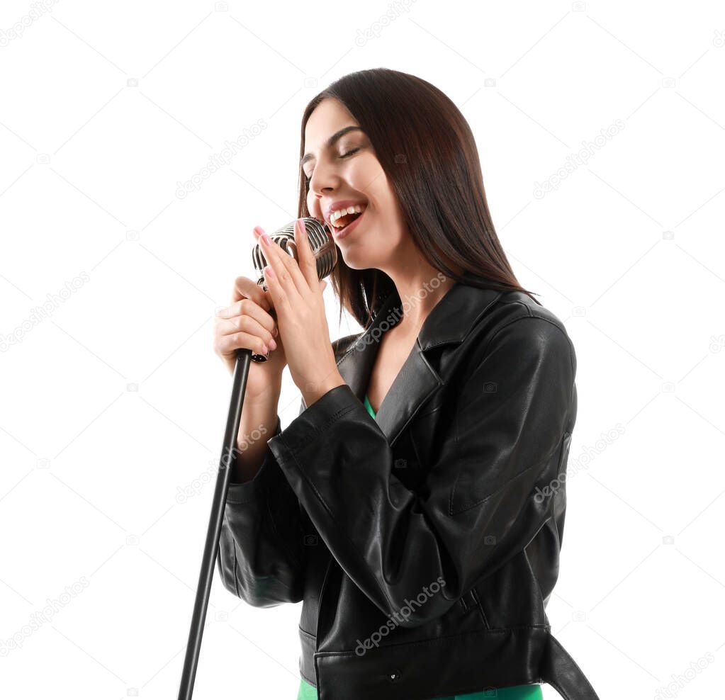 Beautiful young female singer with microphone on white background