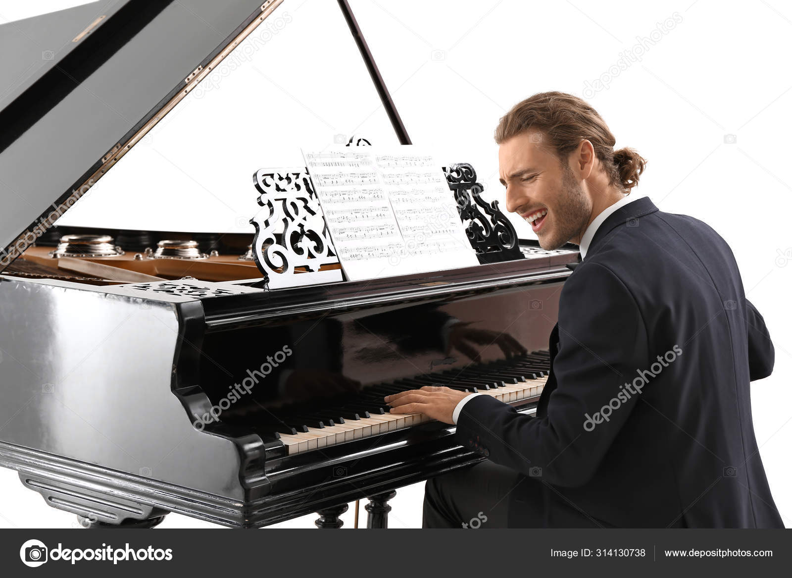 Man playing grand piano at the concert Stock Photo by serezniy