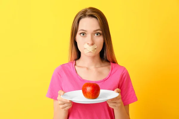 입에 테이프를 부착하고 건강 한 애플 제품을 배경으로 한 여성이죠. 식생활의 개념 — 스톡 사진