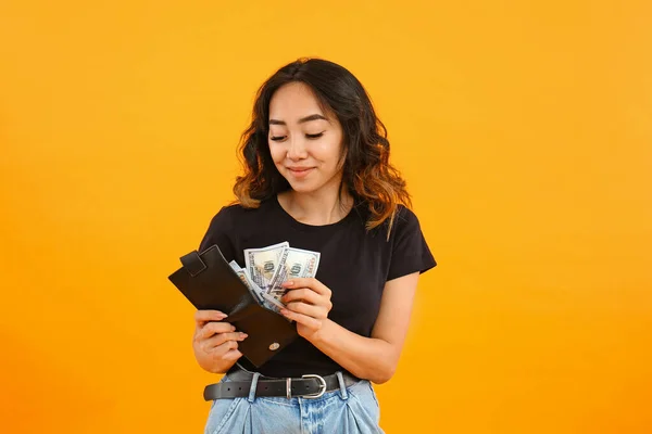 Asiatico donna putting soldi in portafoglio su colore sfondo — Foto Stock