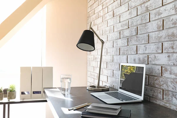 Comfortabele werkplek in de buurt van lichte bakstenen muur — Stockfoto