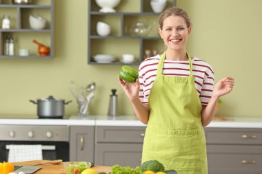 Mutfakta yemek pişiren güzel genç bir kadın.