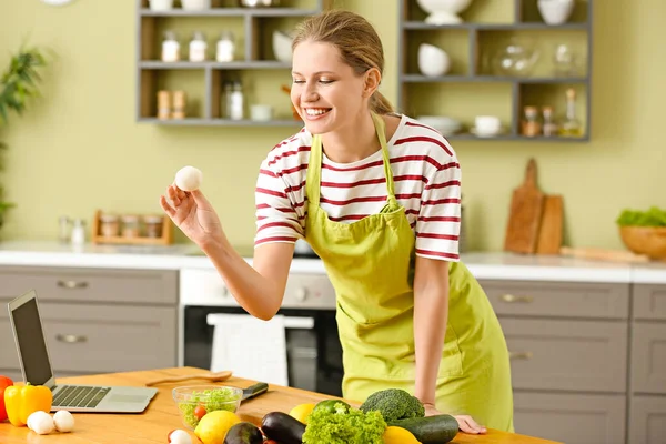 Schöne junge Frau kocht in Küche — Stockfoto