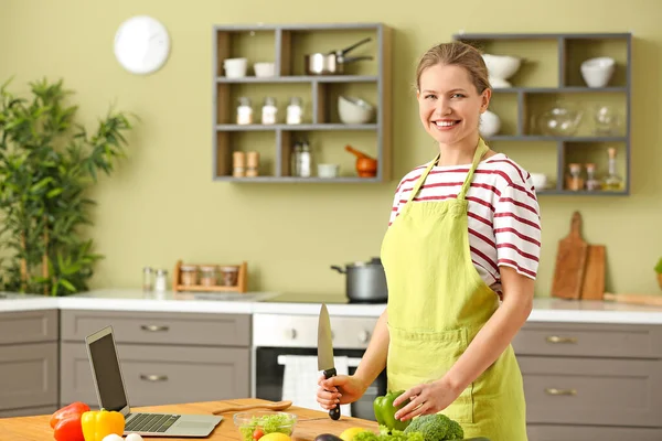 Beautiful young woman cooking in kitchen — Stock Photo, Image