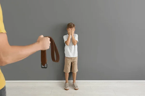 Un homme menace son petit fils près d'un mur gris. Concept de punition physique — Photo