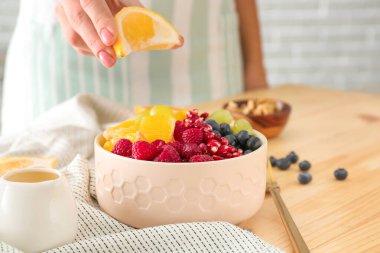 Sofrada lezzetli meyve salatası hazırlayan kadın, yakın plan.