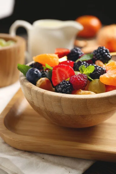 Schüssel mit leckerem Obstsalat auf dem Tisch — Stockfoto