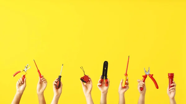 Mãos femininas com ferramentas de eletricista em fundo de cor — Fotografia de Stock