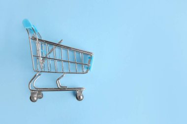 Renkli arka planda boş küçük alışveriş arabası