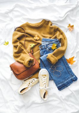 Beyaz kumaşta sonbahar havası için kıyafetlerle kompozisyon